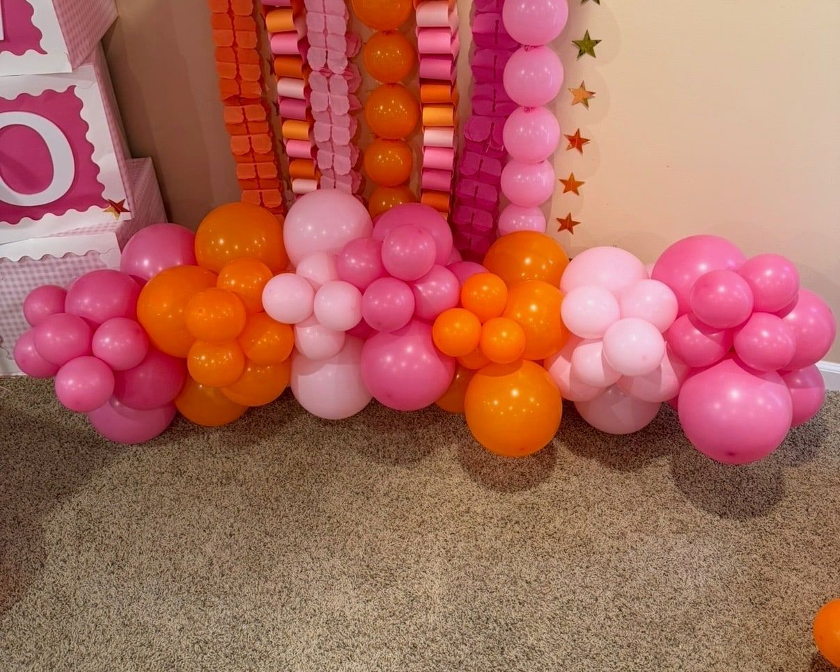 A low organic balloon garland in hot pink, orange and light pink