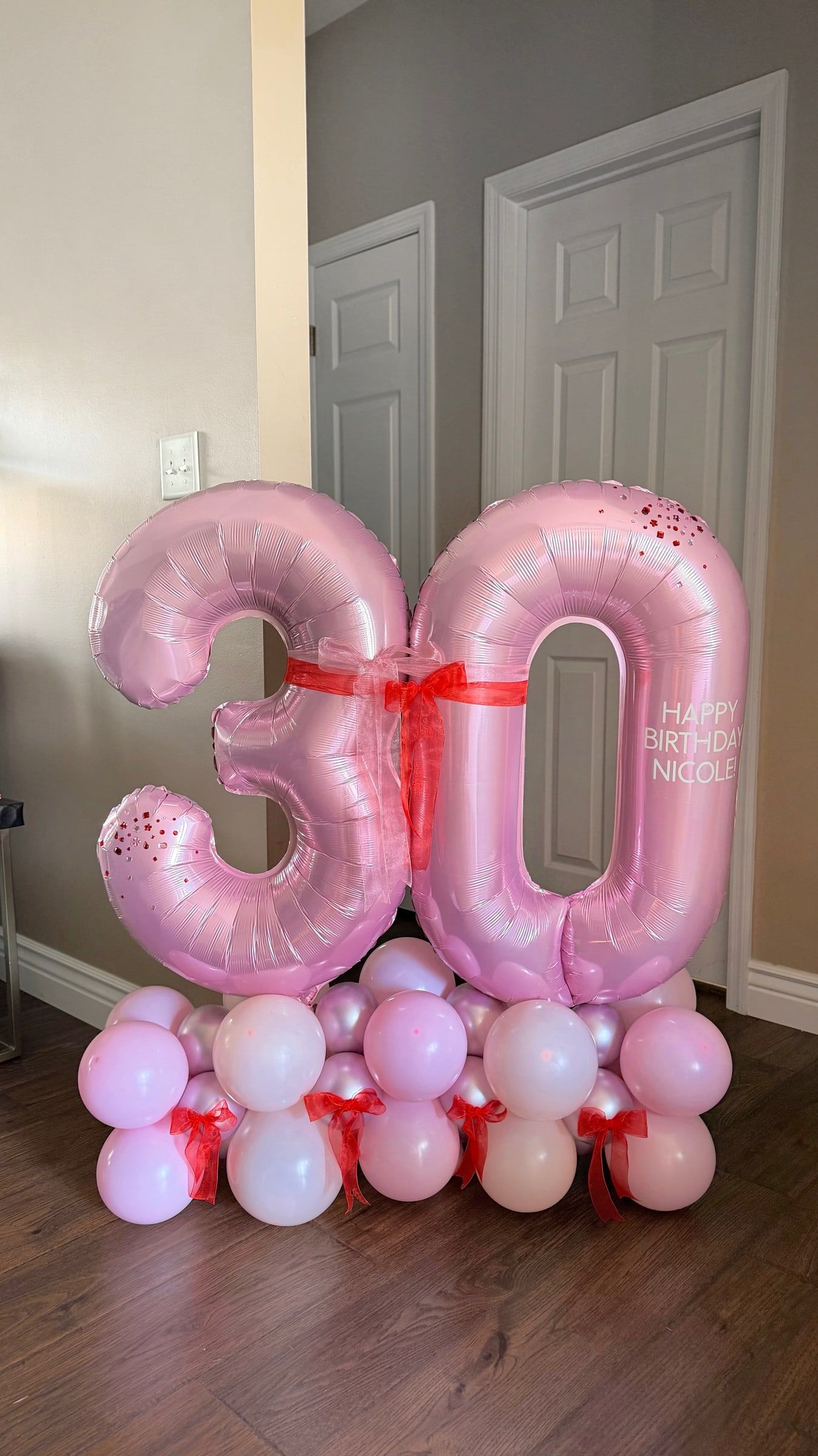 Pink foil 3 and 0 number balloons on a base of pink and white balloons