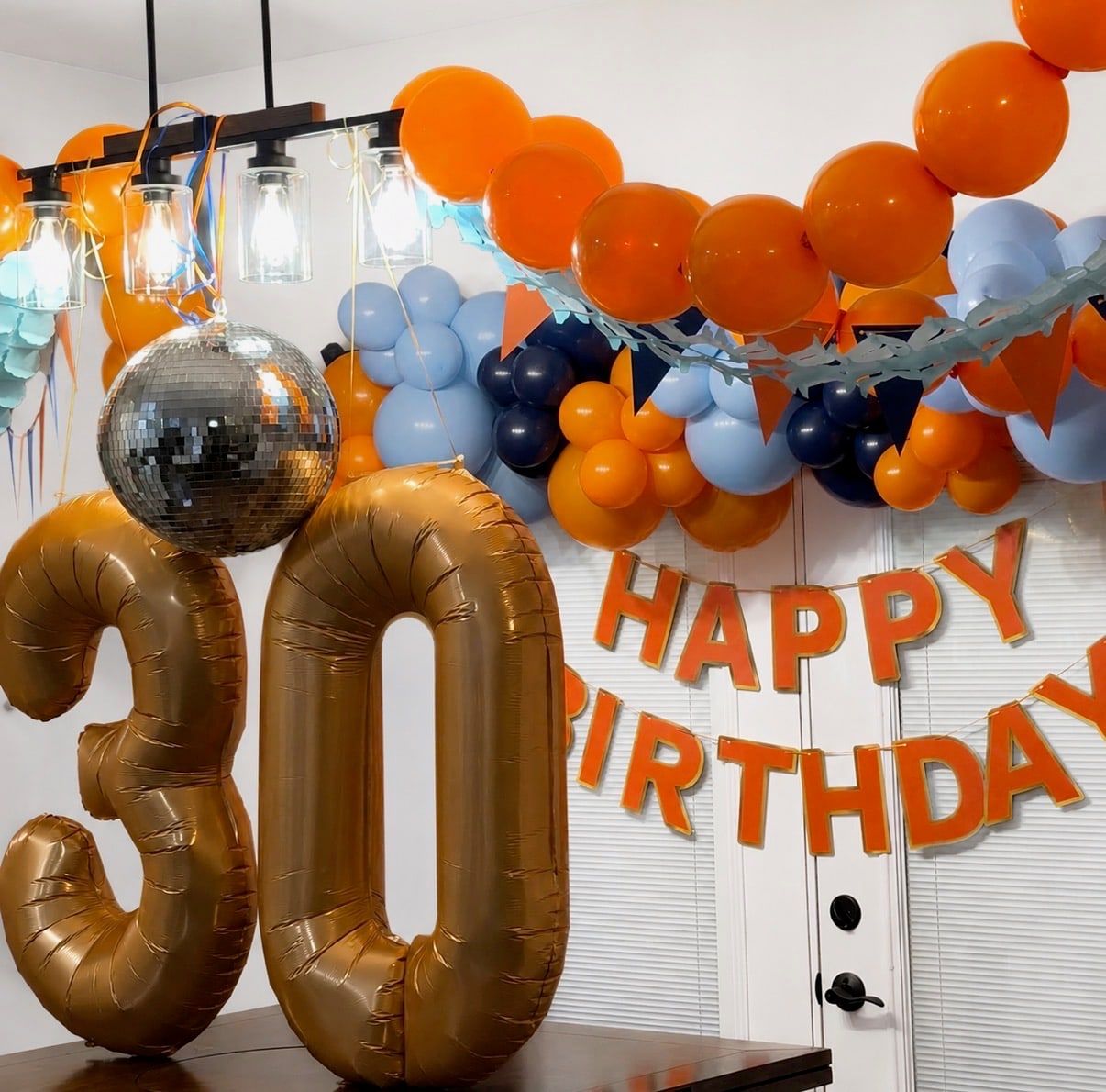 Bronze foil 30 balloons, a disco ball balloon and an orange and blue garland
